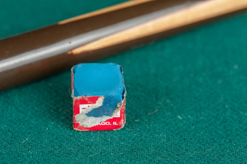 Billiards balls and cue on billiards table. Billiard sport concept. Chalk block on biliard table.