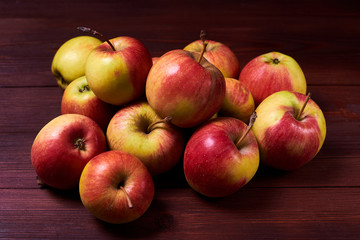 Fresh red-green apples on a wooden background.