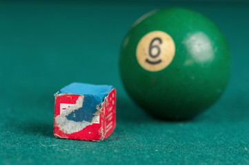 Billiards balls and cue on billiards table. Billiard sport concept. Chalk block on biliard table.