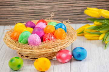 Obraz na płótnie Canvas Beautiful group Easter eggs in the spring of easter day, red eggs, blue, purple and yellow in Wooden basket on the table background wood.