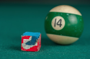 Billiards balls and cue on billiards table. Billiard sport concept. Chalk block on biliard table.