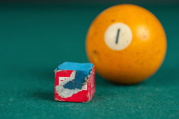 Billiards balls and cue on billiards table. Billiard sport concept. Chalk block on biliard table.