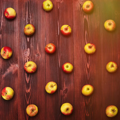 Fresh apples arranged systemically on a wooden background.