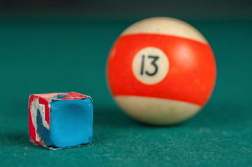 Billiards balls and cue on billiards table. Billiard sport concept. Chalk block on biliard table.