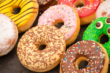 Dessert, Donuts, chocolate and strawberry circles, sugar and cream on Donuts and hot coffee cups, preparation for a break or party on the wooden table background.