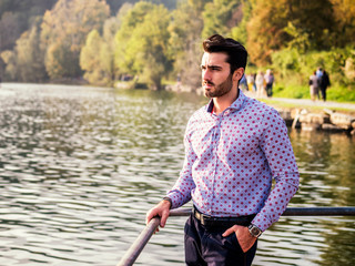 Young man wearing beside picturesque river or lake