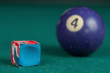 Billiards balls and cue on billiards table. Billiard sport concept. Chalk block on biliard table.