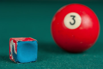 Billiards balls and cue on billiards table. Billiard sport concept. Chalk block on biliard table.