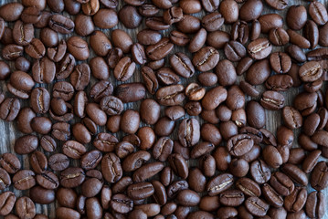 Coffee beans on a wooden table, top view.