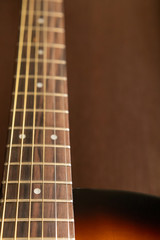 Guitar neck with strings close up on a wooden background