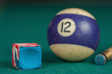 Billiards balls and cue on billiards table. Billiard sport concept. Chalk block on biliard table.