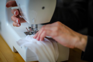 Woman sewing face mask for community to protect themselves against coronavirus
