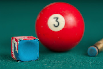 Billiards balls and cue on billiards table. Billiard sport concept. Chalk block on biliard table.