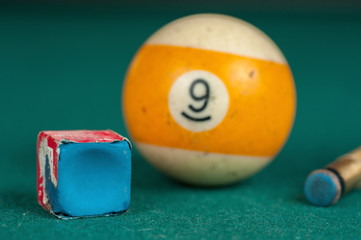 Billiards balls and cue on billiards table. Billiard sport concept. Chalk block on biliard table.