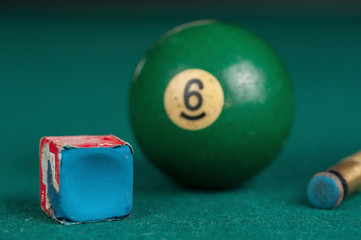 Billiards balls and cue on billiards table. Billiard sport concept. Chalk block on biliard table.