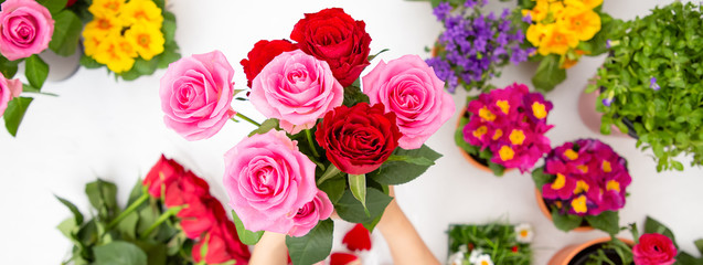Woman Preparing to trim red and pink roses and beautiful flower arrangements in the home, flower arrangements with vase for gift-giving for Valentine's Day and Business in the family on the on table