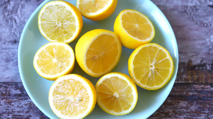 Selective focus. Plate with fresh lemons. Halved lemons on a plate. Vitamins concept.