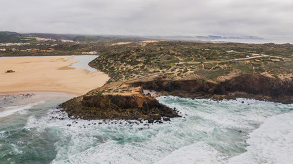 Aerial view of Bordeira beach, in Aljezur, Portugal. Beautiful beach surrounded by cliffs