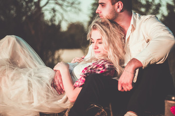 Two lovers on a romantic trip see off the sunset on the outdoor.