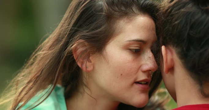 Girl talking to friend ear sharing gossip, Female gossipers