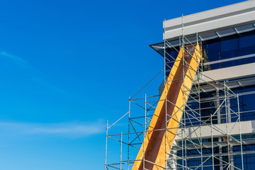 Construction debris chute made from wood installed on scaffolding at the office building. Trash...