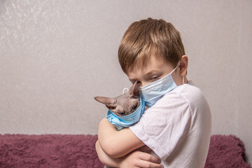 A boy and a bald cat in medical masks protect themselves from the virus, coronavirus, epidemic, air pollution