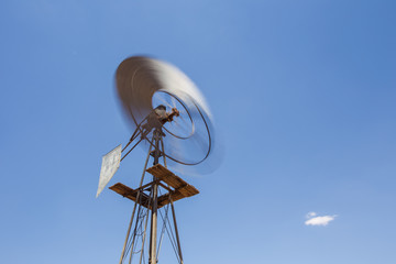 Wide amgle view of a lone windpomp / windmill on the plains of t
