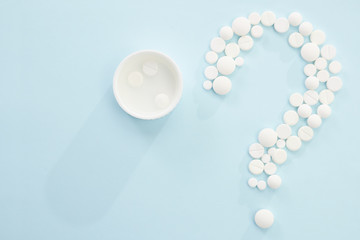 Concept medical of exam, diagnosis and treatment, on blue background with mix pills as question mark