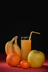 glass of juice with banana and fruits