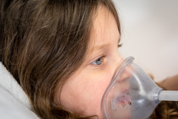 sick little girl is using a medical ventilator