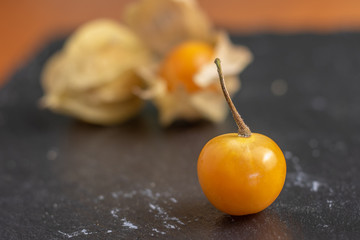 Ripe physalis isolated on a wooden background. Physalis Peruviana 