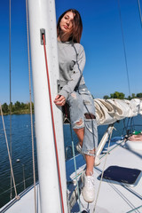 Beautiful young woman posing on yacht. Model is sailing on board.