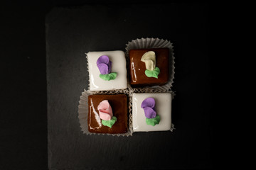 Petite Fours small square cakes in vanilla and chocolate with roses decorated on them