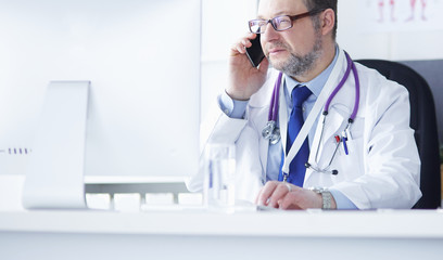 Portrait of senior doctor in office sitting at the desk