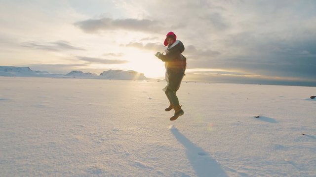 Hipster woman traveler running on snow desert in Iceland at sunset or sunrise. Around Solheimasandur dc3 Plane crash area 