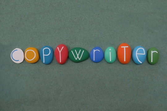 Copywriter, act or occupation of writing text for the purpose of advertising or other forms of marketing composed with multi colored stone letters over green sand