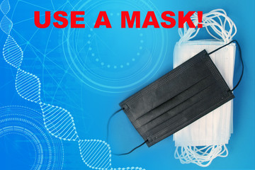 many white and one black protective antiviral medical masks, concept of the SARS-CoV-2 virus...