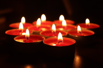 Group of red candles burning in the dark