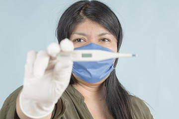 .woman with face mask showing thermometer
