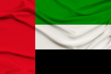 Obraz premium beautiful photograph colored national flag of modern state United Arab Emirates on textured fabric, concept of tourism, emigration, economy and politics, close up