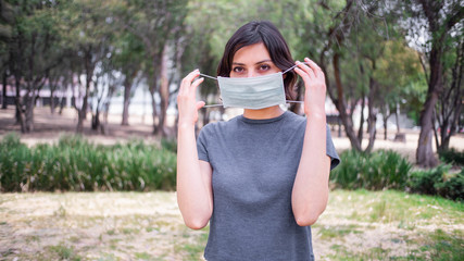 Young woman in park with face mask