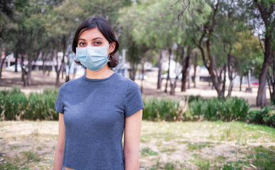 Young woman in park with face mask