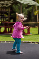 Fototapeta premium Close up image of a little blond toddler girl playing outside