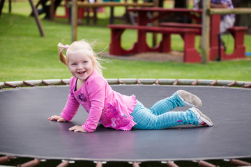 Close up image of a little blond toddler girl playing outside