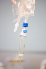 Close up image of a doctor inserting an intravenous line, IV, into the arm of a sick patient