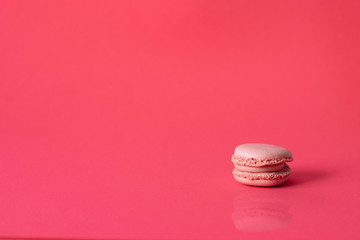 Pink French macaroni on one side on a pink background