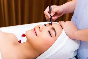 Obraz na płótnie Canvas Young beautiful woman enjoying anti-aging facial massage