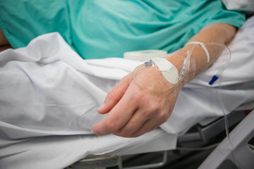 Fototapeta premium Close up image of a doctor inserting an intravenous line, IV, into the arm of a sick patient
