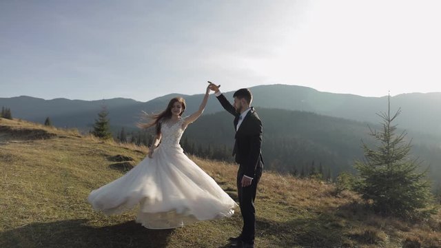 Newlyweds. Caucasian groom with bride dancing on mountain slope. Wedding couple