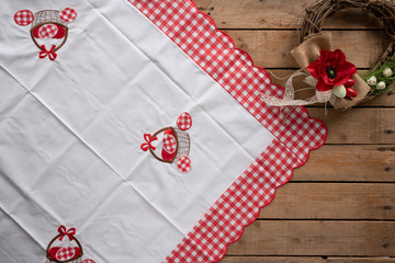 Easter wooden background with a tablecloth and a decorative wreath